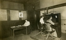 Ruth Pennock, left, and Josie and Alice Smith, seated at the switchboard, work inside the McMahan Telephone Exchange, circa 1900.