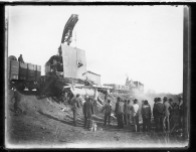 A crowd watches a railroad wrecker working the scene of a derailment near Volland, Kansas, circa, 1905.