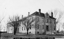 The Wabaunsee County Courthouse is seen in this real photo postcard created by Zercher Photo in about 1910. At the far left of the image at the rear of the building one can see the top of the fence surrounding the rock pile. The County Jail was located in the back portion of the building.