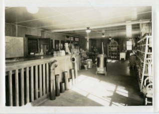 Leland Lucky, manager of the Clinton Scott Lumber Company stands at the counter in this 1930s view of the lumber company before the addition was added to the east.